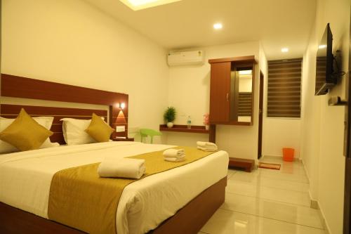 a bedroom with a large bed with towels on it at Misty Avenue Premium Rooms in Anachal