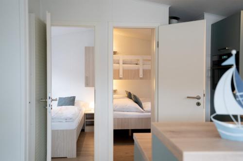 a bedroom with two beds and a mirror at Ostseecamp Lübecker Bucht Ferienhaus "JU-LI" mit kostenlosen Saunazugang in Scharbeutz