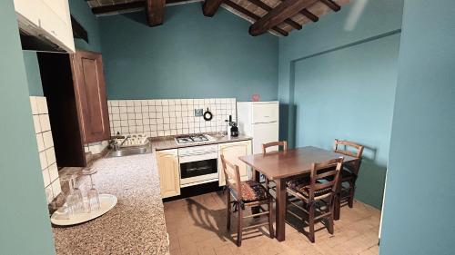 a kitchen with a table and a table and chairs at Corte Fratini Appartamenti in Trevi