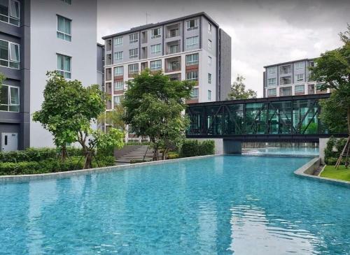 清邁的住宿－An Na Park Hotel Room - Chiang Mai，一座桥,在游泳池上方,有建筑物