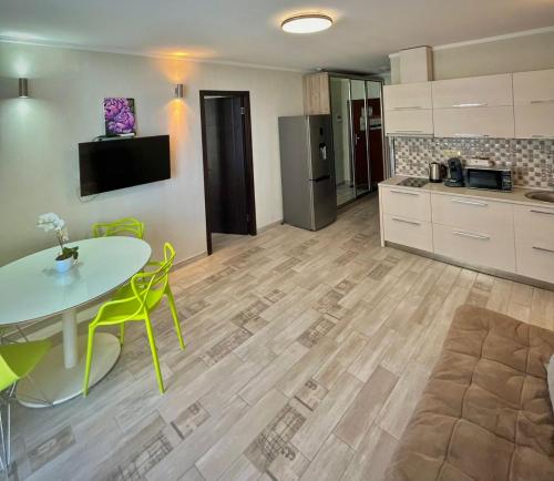 a kitchen with a table and yellow chairs in a room at Holiday Premium Apartments Batumi in Batumi