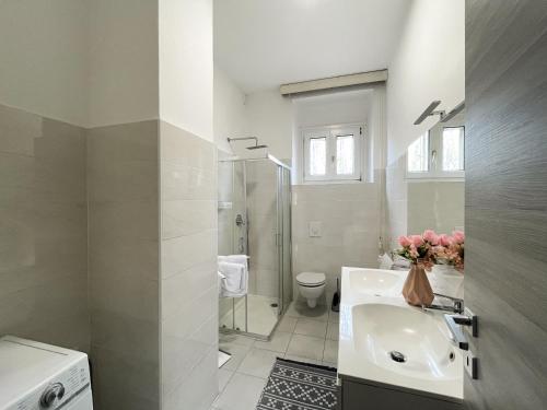 een witte badkamer met een wastafel en een douche bij Casa Felicity Verona in Verona