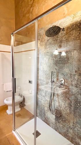 a glass shower in a bathroom with a toilet at Corte Fratini Appartamenti in Trevi