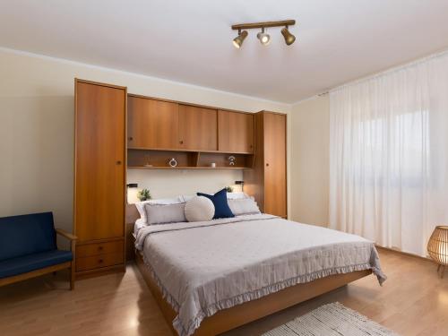 um quarto com uma cama grande e uma cadeira azul em Marisan Seaview Apartment em Funtana