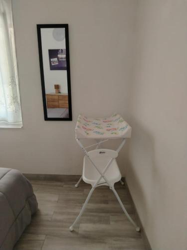 una pequeña mesa blanca en una esquina de un dormitorio en LOFT, en Mezzolombardo