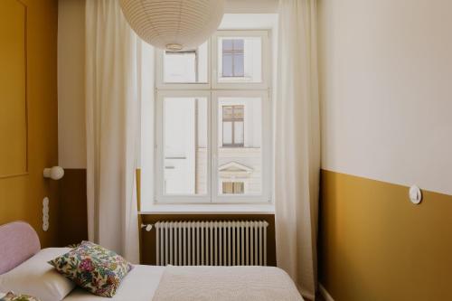 a bedroom with a bed and a window at Apartments Floriańska 24 in Krakow
