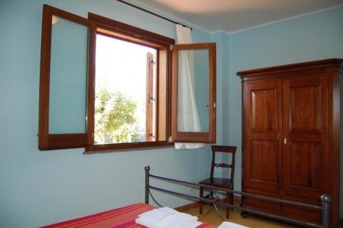a bedroom with a bed and two windows at Apartment mit Terrasse - b57363 in Acireale