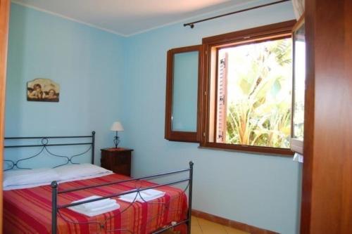 a bedroom with a bed and a window at Apartment mit Terrasse - b57363 in Acireale