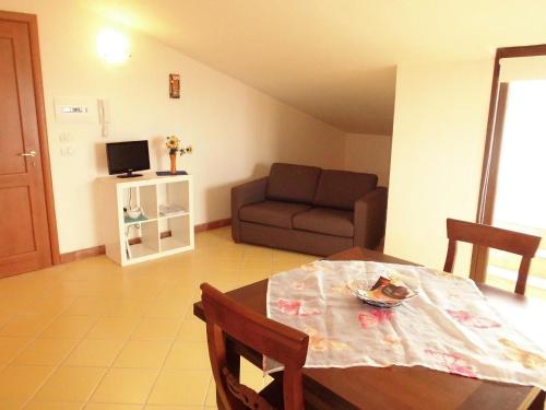 - un salon avec une table et un canapé dans l'établissement Nette Wohnung in Acireale mit Terrasse und gemeinsamem Pool, à Acireale
