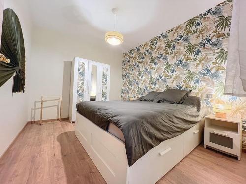 een slaapkamer met een groot bed met een bloemenmuur bij Logement T3 Demeure d'exception in Cénac