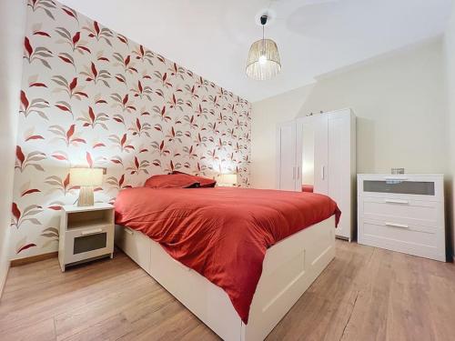 ein Schlafzimmer mit einem großen Bett mit einer roten Decke in der Unterkunft Logement T3 Demeure d'exception in Cénac