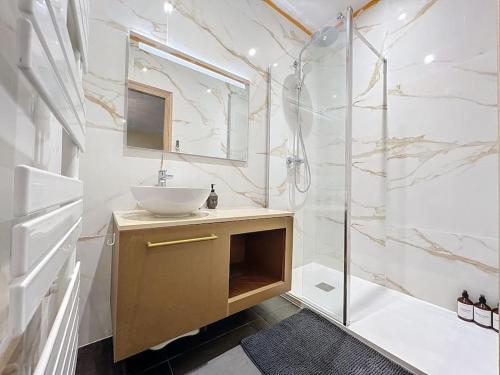 ein weißes Bad mit einem Waschbecken und einer Dusche in der Unterkunft Logement T3 Demeure d'exception in Cénac