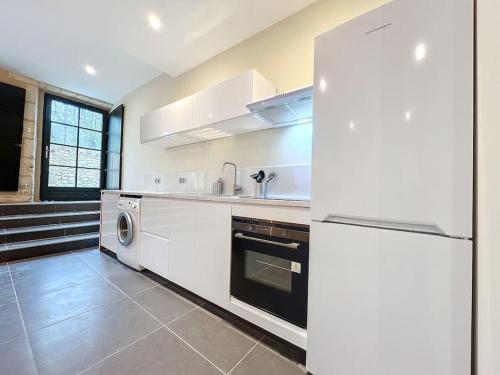 een keuken met een koelkast, een wasmachine en een droger bij Logement T3 Demeure d'exception in Cénac