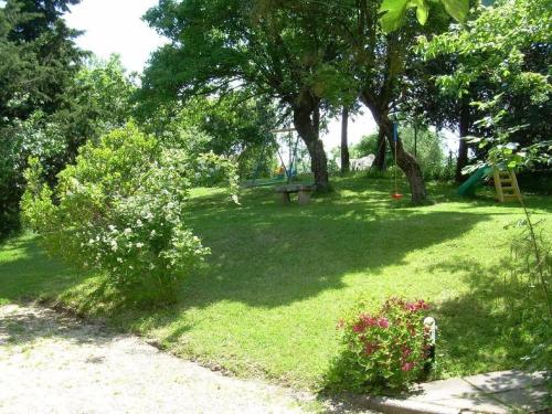 einen Park mit einer Bank, Bäumen und einem Spielplatz in der Unterkunft Il CASETTINO - Ferienwohnungen mit pool in Radicondoli