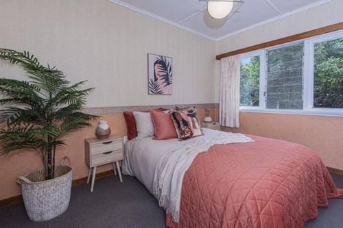 a bedroom with a bed and a potted plant at Rest & Relax villa Whangarei 4 Bedrooms 2 Bath family home in Whangarei