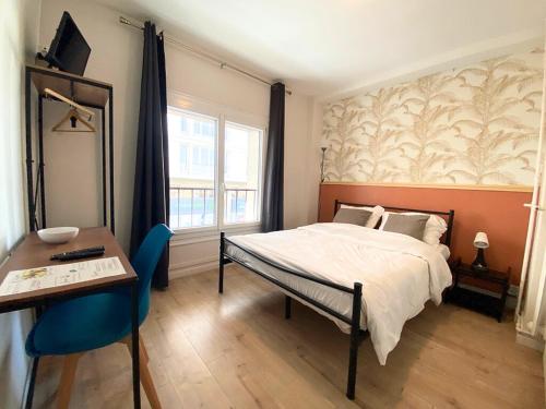 勒阿弗爾的住宿－L'Escale Appartements et Suites en bord de Mer，一间卧室配有一张床、一张桌子和一张书桌
