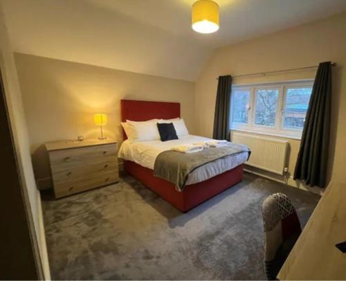 1 dormitorio con 1 cama, vestidor y ventana en Spacious 4 bedroom house., en Earley