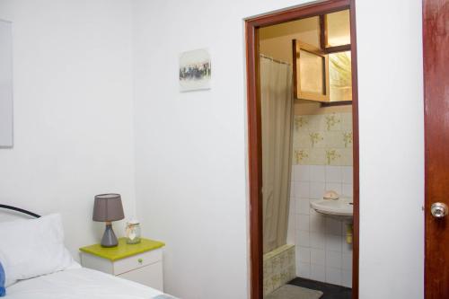 1 dormitorio con 1 cama y baño con lavamanos en Habitación en Chiclayo (Santa Victoria), en Chiclayo