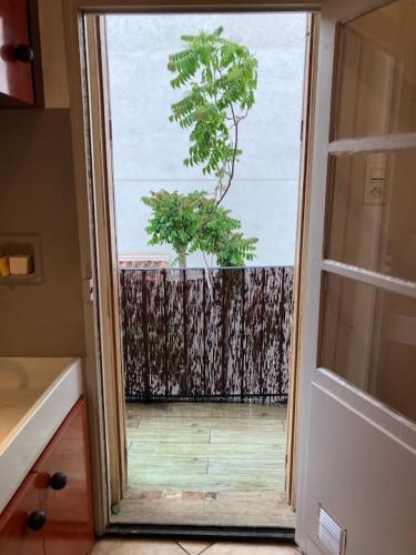 une porte menant à un balcon avec un arbre à l'extérieur. dans l'établissement Appartement cosy à 2 pas de la gare, à Marseille