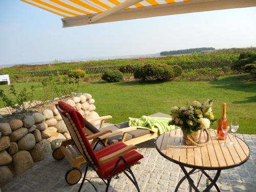 un patio con mesa y sillas con vistas en Ferienwohnung für 2 Personen ca 55 qm in Munkmarsch, Nordfriesische Inseln Sylt, en Munkmarsch