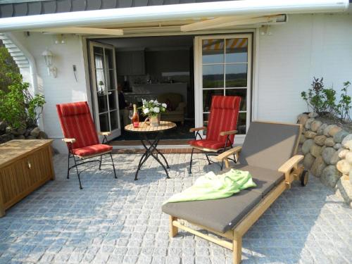 um pátio com 2 cadeiras, uma mesa e uma mesa em Ferienwohnung für 2 Personen ca 55 qm in Munkmarsch, Nordfriesische Inseln Sylt em Munkmarsch