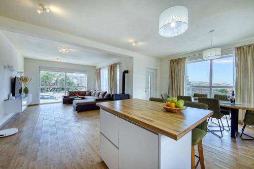 a kitchen and living room with a table with a bowl of fruit at Temida in Rovanjska