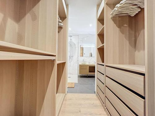 een inloopkast met houten planken en een badkamer bij Logement T2 Demeure d'exception in Cénac