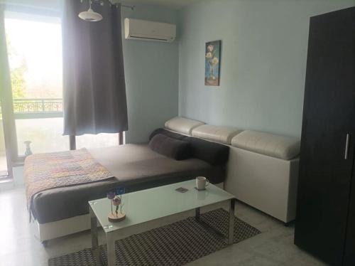 a small bedroom with a bed and a table at Central Studio Maritsa in Plovdiv