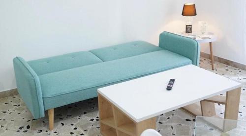 a blue couch in a living room with a table at Licia's home in Palermo