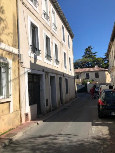 un bâtiment avec une voiture garée à côté d'une rue dans l'établissement Jolie studio à deux pas du centre historique, à Montpellier