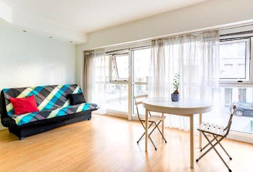 ein Wohnzimmer mit einem Sofa und einem Tisch in der Unterkunft Le Saso in Lyon