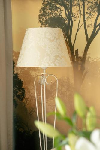 a lamp with a white shade next to a tree at Juvena Hotel Wellness & SPA Adults Only 12 plus in Międzywodzie