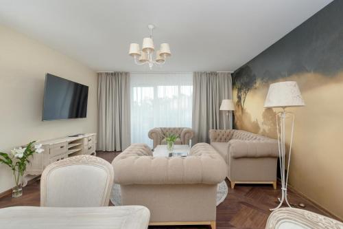 a living room filled with furniture and a flat screen tv at Juvena Hotel Wellness & SPA Adults Only 12 plus in Międzywodzie