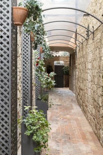 an arcade with plants on the side of a building at Hotel & Residenza 100 Torri in Ascoli Piceno