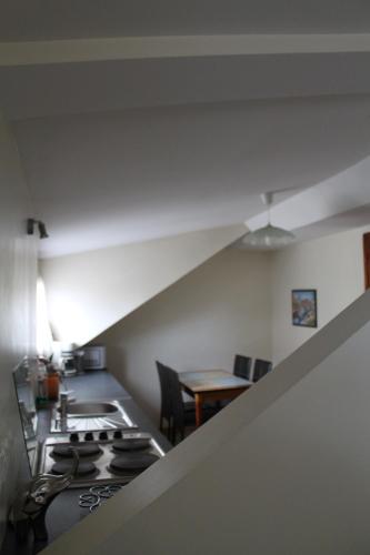 Il comprend une cuisine équipée d'une cuisinière. four supérieur à côté d'une table dans l'établissement Location G&W, très proche sanctuaires II, à Lourdes