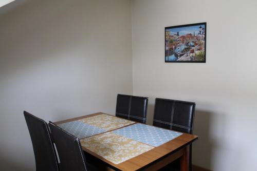 une table à manger avec des chaises et une photo sur le mur dans l'établissement Location G&W, très proche sanctuaires II, à Lourdes