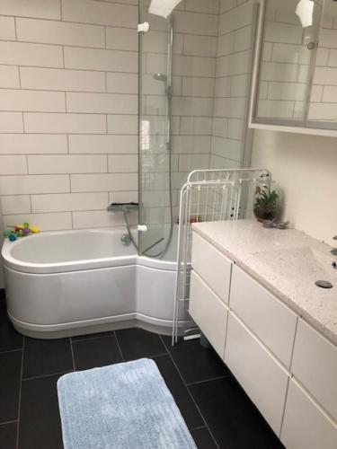y baño con bañera, ducha y lavamanos. en Great house in beautiful surroundings en Aalborg