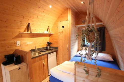 a bedroom with a bed in a log cabin at Wood Cabin 2 personen in Baarle-Nassau