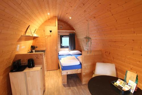 una piccola camera con due letti in una cabina di Wood Cabin 2 personen a Baarle-Nassau