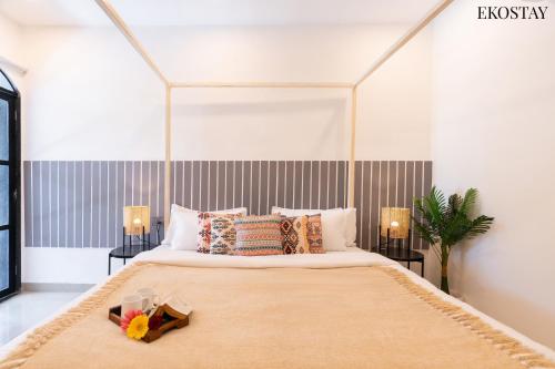 a bedroom with a large bed with two lamps at EKOSTAY Luxe - Casa Roma in Alibaug