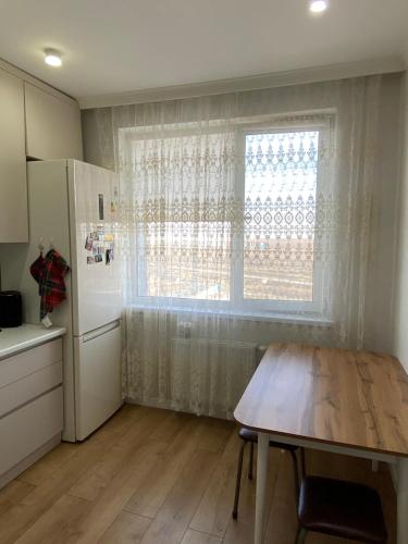 cocina con mesa de madera y ventana en жилой комплекс AMAN en Prigorodnyy