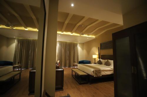 a hotel room with a bed and a couch at Essentia Luxury Resort & Spa Udaipur in Udaipur