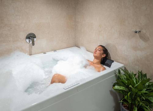 a woman is sitting in a bath tub at The Grand Cliff Resort Munnar in Viripara