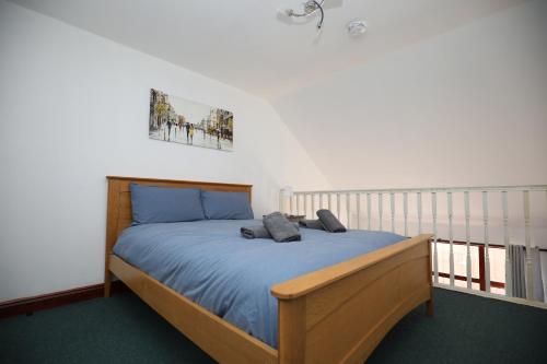 Schlafzimmer mit einem Bett mit blauer Decke in der Unterkunft Luxury 1 Bed - Duplex Apartments in Leicester