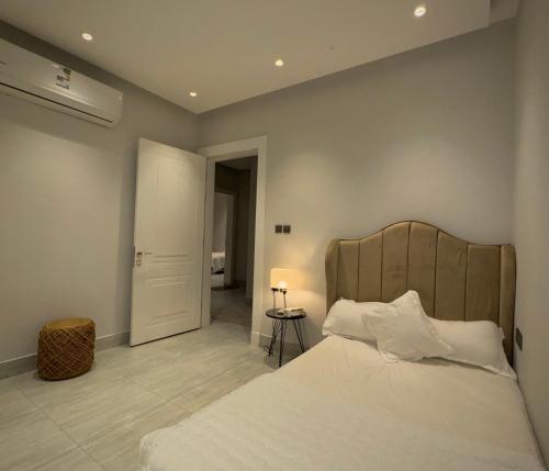 a bedroom with a large bed with a wooden headboard at شقة فندقية الماجدية مدخل خاص in Riyadh