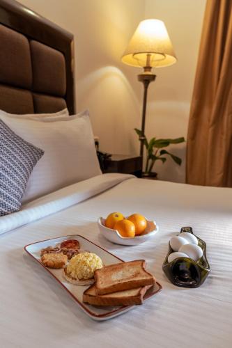 a tray of breakfast foods on a bed at Casabela Boutique Hotel in Porvorim