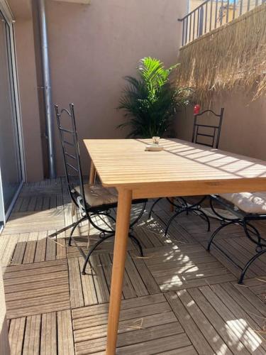 uma mesa de madeira e 2 cadeiras num pátio em Appartement T2 - Résidence de style Méditerranéen em Carqueiranne