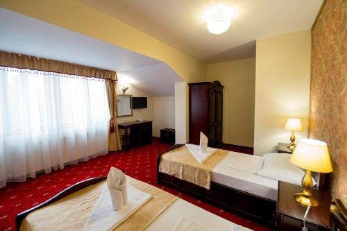 a hotel room with two beds and a table at Pensiunea Oscar in Focşani