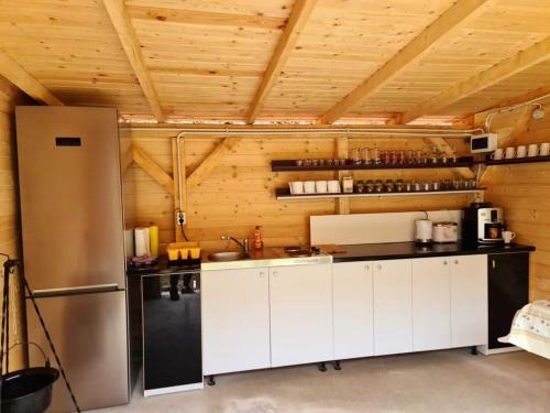 a kitchen with white cabinets and a refrigerator at Moara de Pădure in Cluj-Napoca