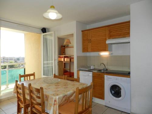 une cuisine avec une table et une cuisine avec un lave-linge dans l'établissement Appartement Familial 3 Pièces, 6 Couchages, Proche Plage et Commerces - Bormes-les-Mimosas - FR-1-251-798, à Bormes-les-Mimosas